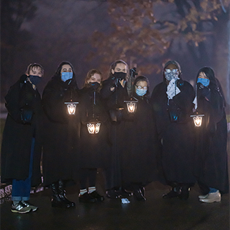 students with lanterns at night